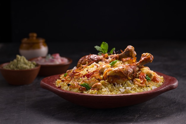 Chicken dhum biriyani using jeera rice and spices arranged in  earthen ware