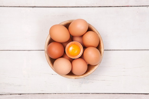 Chicken egg in wood bowl on wood table with space for copy .&#xA;