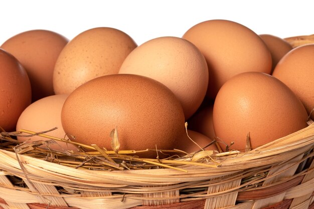 Chicken eggs in basket Isolated on white surface close up