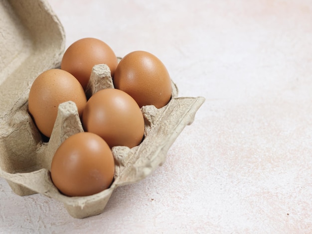 chicken eggs in cardboard box over white background