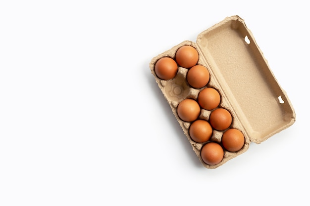 Chicken eggs in egg box on white