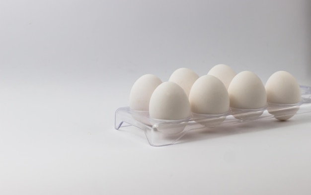 Chicken eggs in a tray on a white background Ingredients for cooking