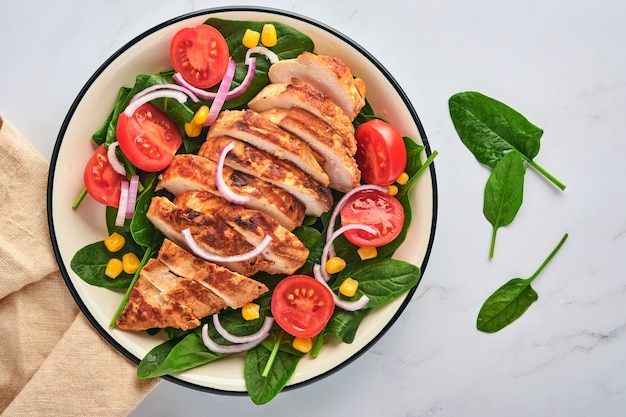 Chicken fillet with salad spinach, cherry tomatoes, cornflower and onion