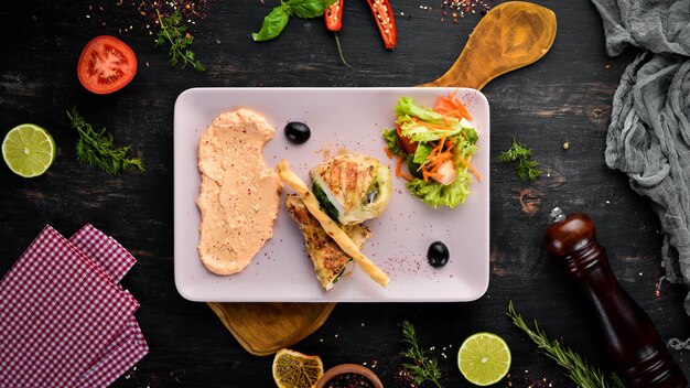 Chicken fillet with spinach cheese and mushrooms On a wooden background Top view Free space for your text