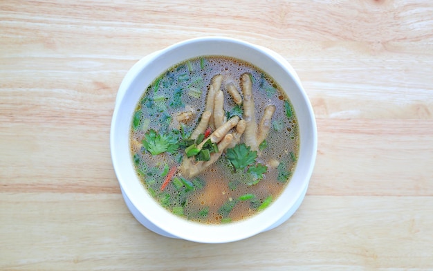 Chicken Foot with hot and sour soup in bowl on wood table background Thai food Top view