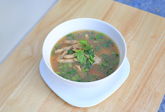 Chicken Foot with hot and sour soup in bowl on wood table background Thai food