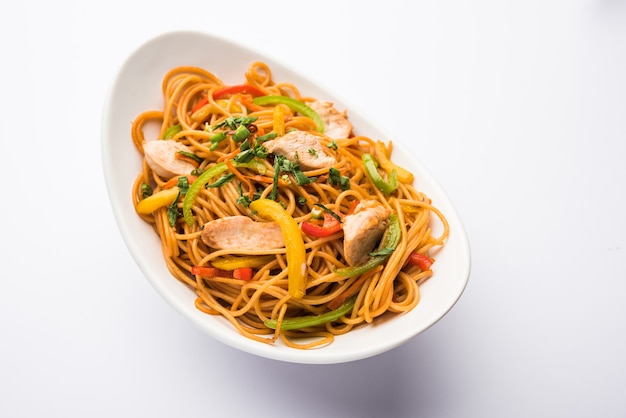 Chicken Hakka or Schezwan noodles served in a bowl with chopsticks. selective focus