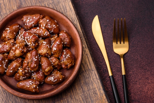 Chicken hearts fried in soy sauce with salt and spices in a plate