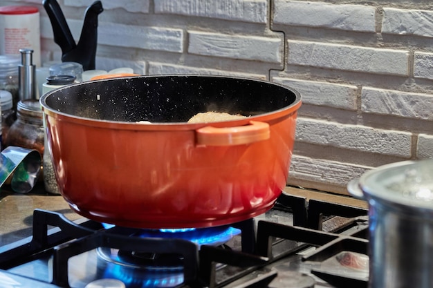 Chicken is cooked in pot on gas stove in the kitchen