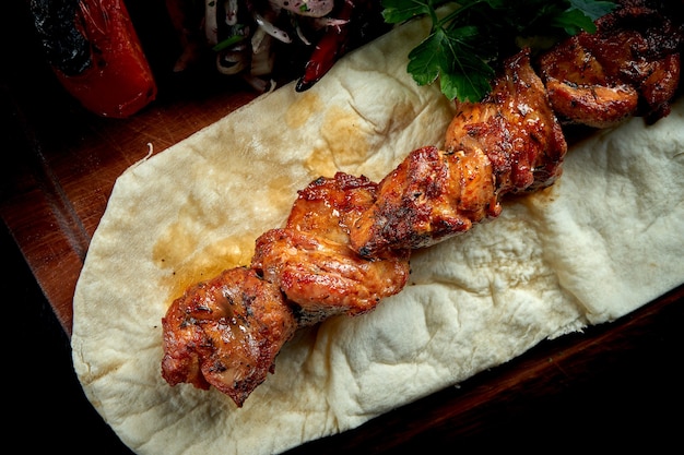 Chicken kebab cooked on the grill with lavash, bulgur and grilled vegetables on wooden board. Turkish kebab. Close up ,selective focus