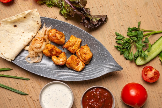 chicken kebab in a gray ceramic plate top view