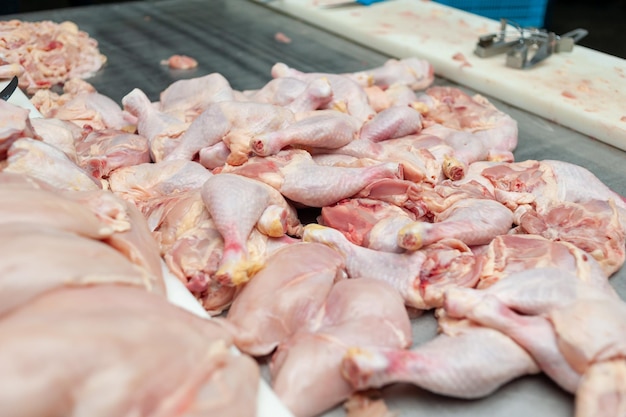 Chicken legs on a table in a meat processing facility.