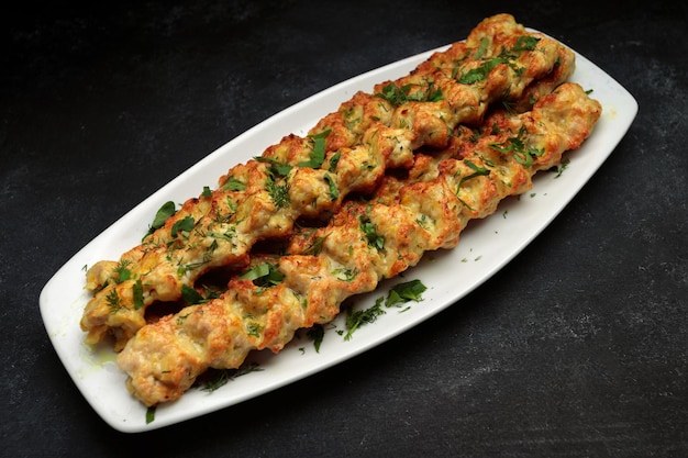 Chicken lulia kebab with herbs on a plate