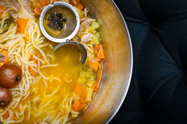 Chicken noodle soup isolated on black surface