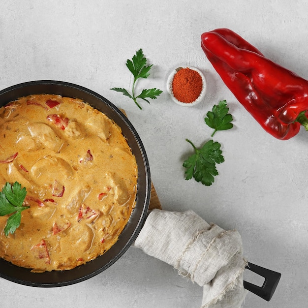 Chicken paprikash dish with paprika onion bulgarian paper on pan