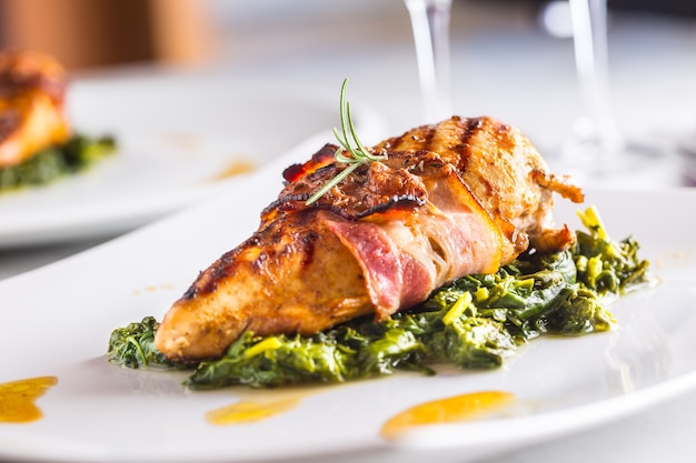 Chicken roasted breast with bacon and spinach on white plate Culinary food  in hotel  or restaurant