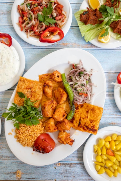 Chicken shish kebab in a plate with appetizers