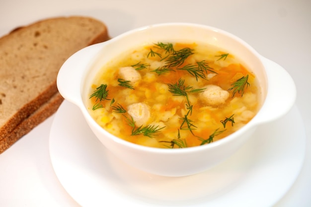 Chicken soup with meatballs and pasta on the table