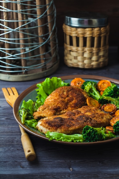 Chicken steak in breadcrumbs with vegetables on a plate