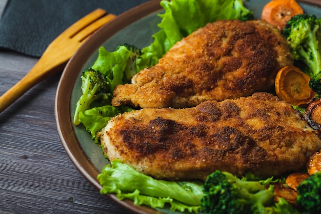 Chicken steak in breadcrumbs with vegetables on a plate