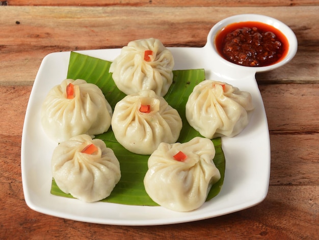 Chicken steam momo Nepalese Traditional dish Momo stuffed with chicken and then cooked and served with sauce over a rustic wooden background selective focus