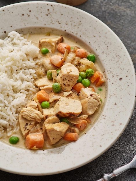 Chicken stew with vegetables and mushroom cream sauce Tender chicken fillet in a creamy mushroom sauce with rice and green peas