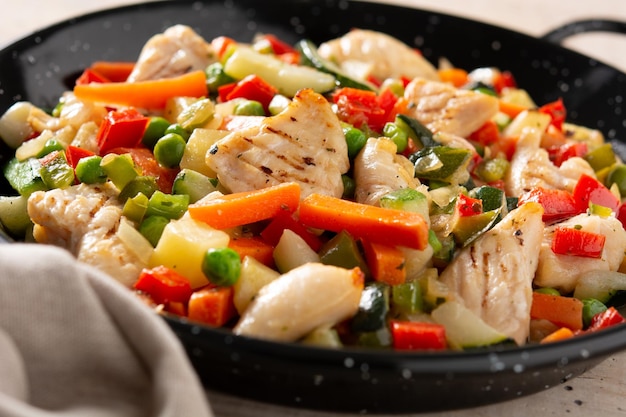 Chicken stir fry and vegetables on wooden table