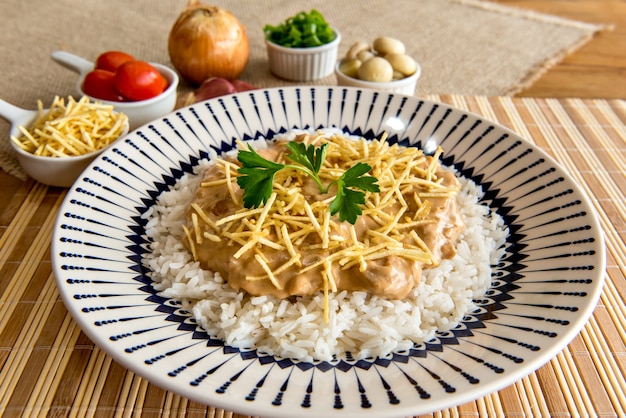 Chicken stroganoff, straw potatoes and white rice. Brazilian cuisine.