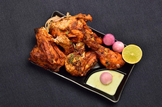 Chicken Tandoori with chutney lemon and onion in plate