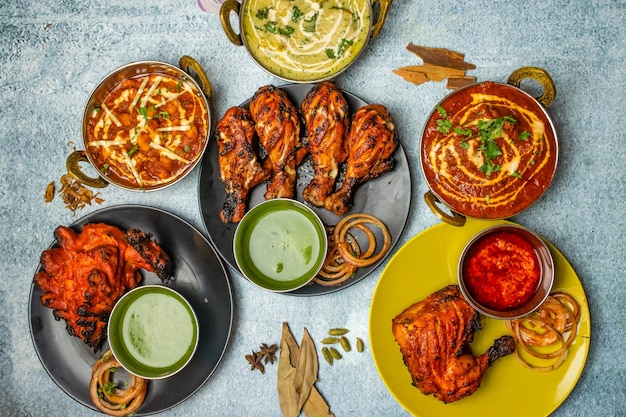 Chicken Tikka Butter Masala Reshmi masala Ginger Chicken Tangri Kabab Lal Badsha tandoori Peri peri with chili sauce served in a dish isolated on grey background top view of bangladesh food