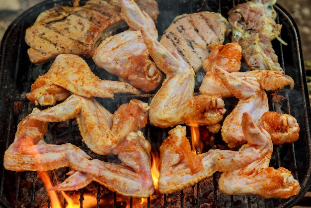 Chicken wings on barbecue grill with fire