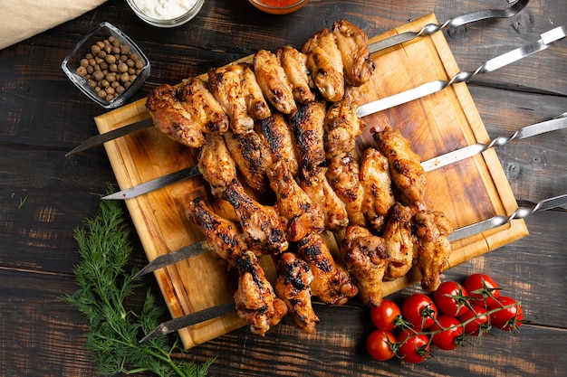 Chicken wings cooked on skewers on wooden