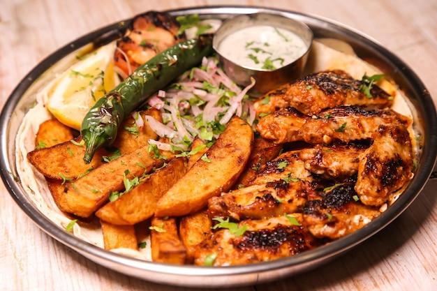 Chicken wings platter with wedges dip chilli onion and lemon served in dish isolated on background top view of arabic food