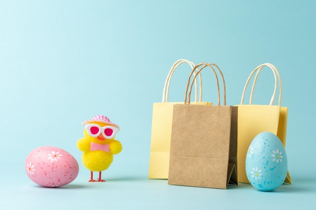 Chicken with Easter eggs and shopping bags on blue background