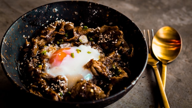 Chicken with rice, onions and broccoli on the table. horizontal view from above. Japanese food rice serves with chicken in Teriyaki sauce and egg