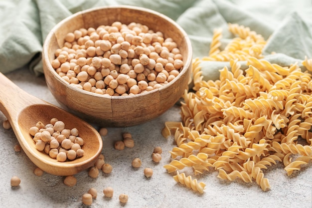 Chickpea bean fusilli pasta on a gray concrete background Bowl with raw pasta and chickpea bean Gluten free pasta