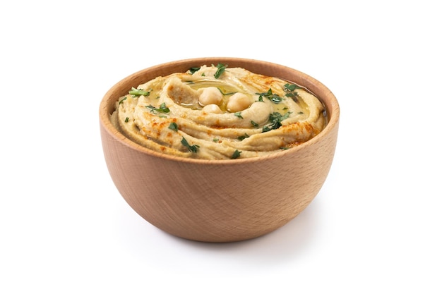 Chickpea hummus in a wooden bowl garnished with parsley paprika and olive oil isolated on white background