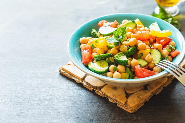 Chickpea salad with tomatoes cucumber parsley onions in a plate selective focus Healthy vegetarian food oriental and Mediterranean cuisine Chick peas salad