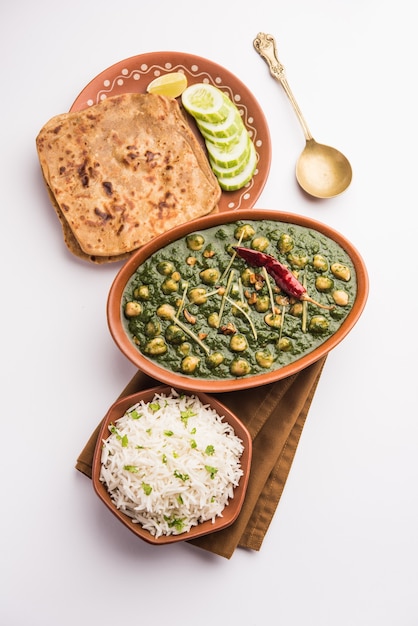 Chickpea Spinach Curry or Chana Masala with Palak served with Rice and flatbread or Paratha, selective focus