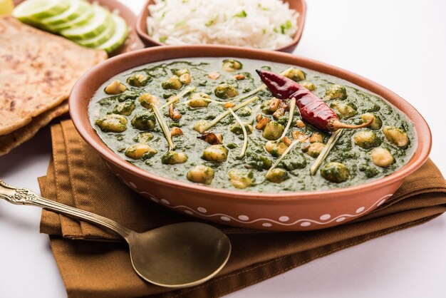 Chickpea Spinach Curry or Chana Masala with Palak served with Rice and flatbread or Paratha, selective focus