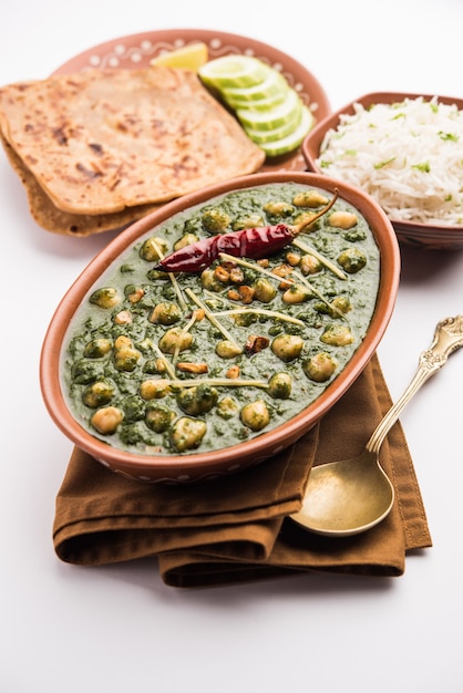 Chickpea Spinach Curry or Chana Masala with Palak served with Rice and flatbread or Paratha, selective focus