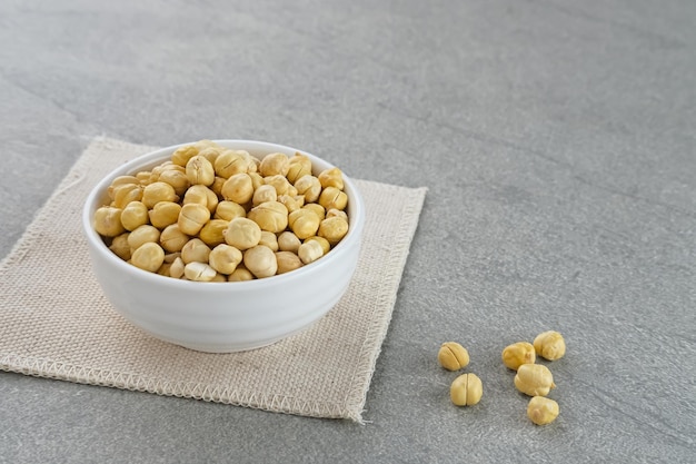 Chickpeas in white bowl on grey background Space for text