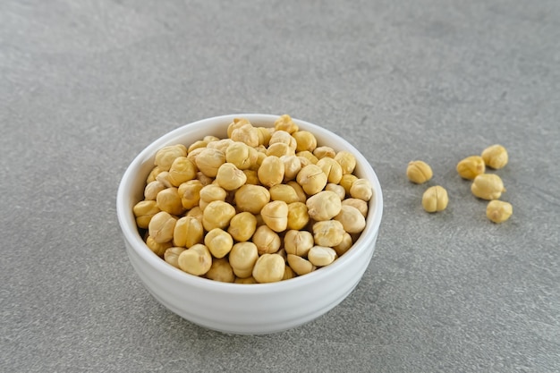 Chickpeas in white bowl on grey background Space for text