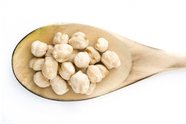 Chickpeas on wooden spoon isolated  top view