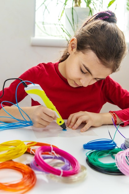 Child 3D drawings with a pen on the table Selective focus