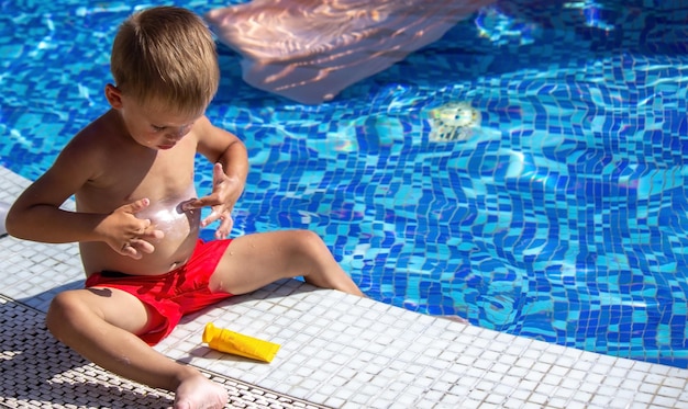 A child applying sunscreen to his stomach