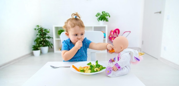 Child baby eats pasta with vegetables Selective focus Food