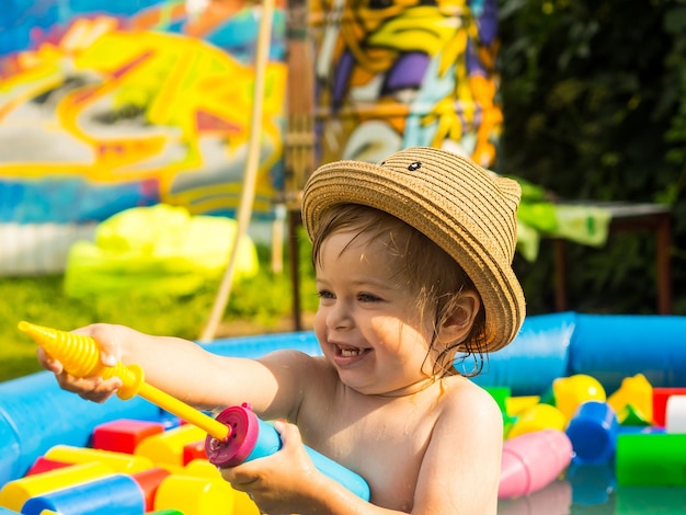 The child bathes in an inflatable pool plays and splashes