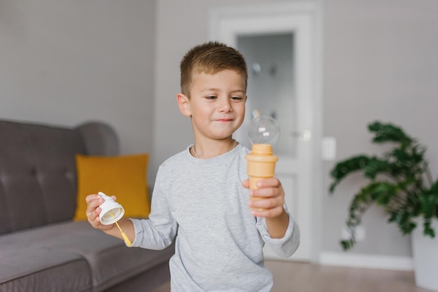 Child boy holding a soap bubble in his hands Children's games at home