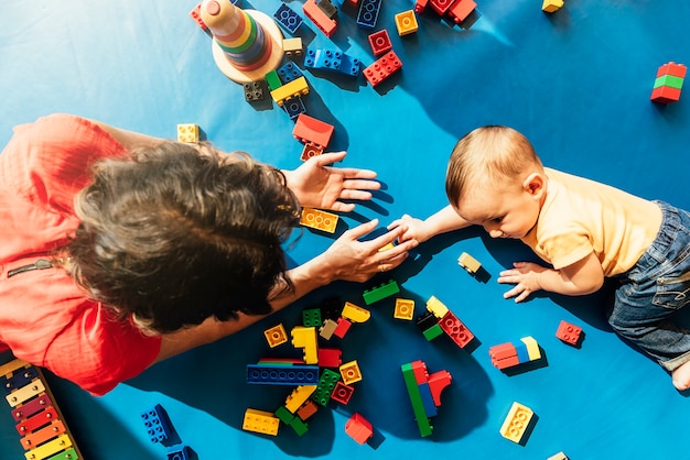 Child boy and mother playing with educational toy.